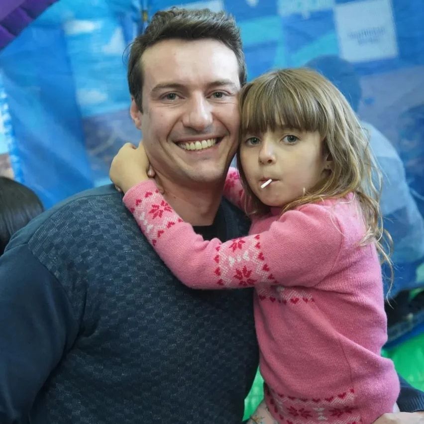 Raphael hugging his daughter at an amusement park