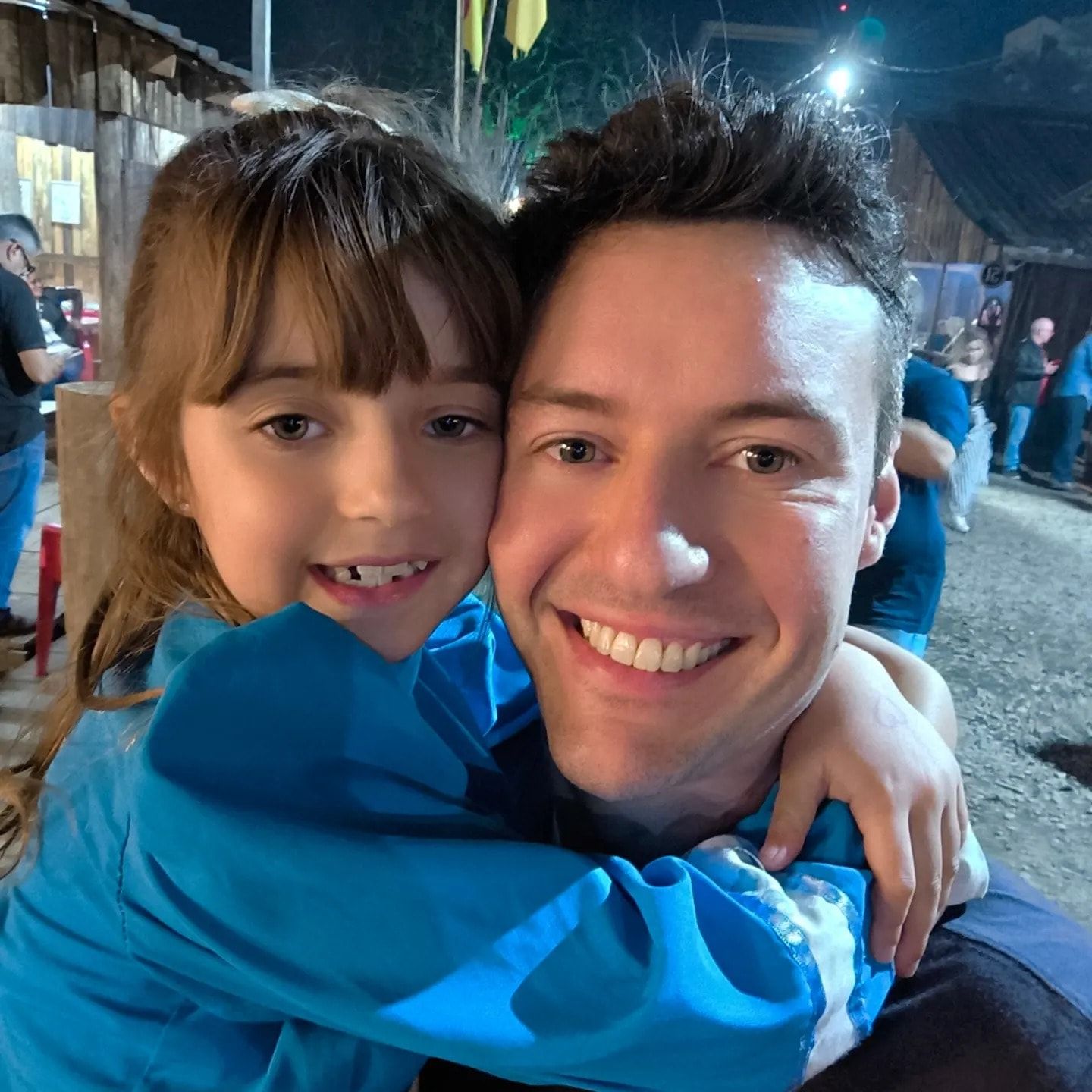 Raphael and his daughter hugging during Semana Farroupilha, a gaúcho heritage festival