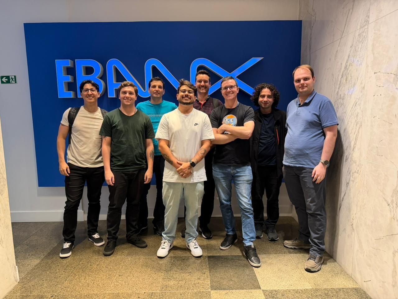 Raphael Bohrer with the engineering team in front of the EBANX logo